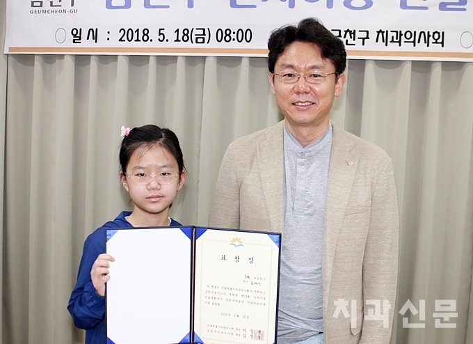 금천구회 김정무 회장(우)이 구 건치아동 대표로 선발된 김혜민(서울문백초 5) 학생(좌)과 기념사진을 촬영하고 있다.