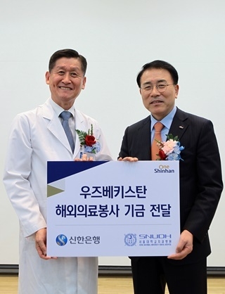 신한금융그룹 조영병 회장(사진 우)이 서울대치과병원 허성주 원장에게 해외의료봉사 기금을 전달하고 있다.