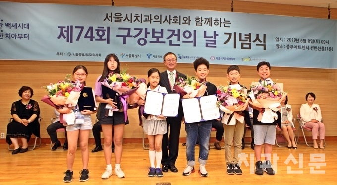 제74회 구강보건의 날을 맞아 충무아트센터에서 진행된 기념식에서 서울시치과의사회 이상복 회장과 서울시를 대표해 건치아동으로 선발된 수상자들이 포즈를 취하고 있다.
