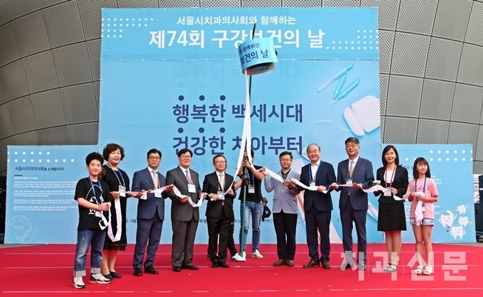 구강보건의 날 행사의 개막을 알리는 박터트리기 퍼포먼스를 서울시치과의사회 이상복 회장을 비롯한 내외빈들이 함께 하고 있다.