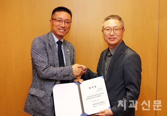 서울치과의사회 이상복 회장(사진 우)이 선거관리규정개정특위 정관서 위원장(사진 좌)에게 위촉장을 전달하고 있다.