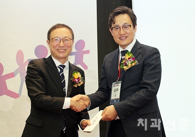서울시치과의사회 이상복 회장(좌)이 재경연합회 김응호 회장(우)에게 격려금을 전달하고 있다.