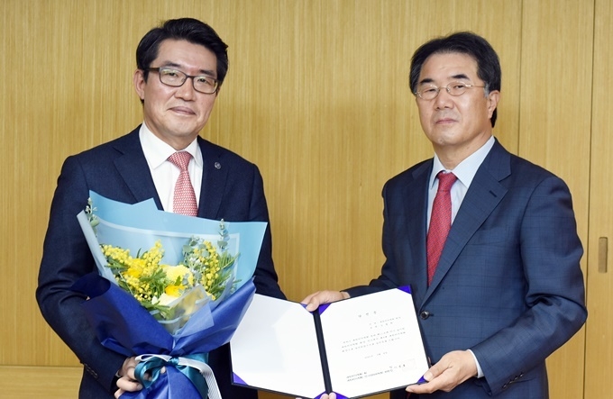 대한치의학회 선거관리위원장을 겸하고 있는 이종호 치의학회장(사진 우)이 김철환 당선인(사진 좌)에게 당선증을 전달하고 있다.