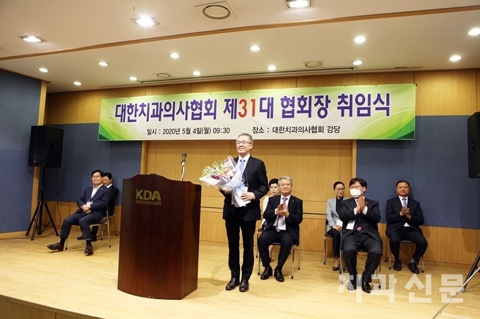 이상훈 회장이 취임을 축하하는 꽃다발을 전달받고 환하게 웃고 있다.