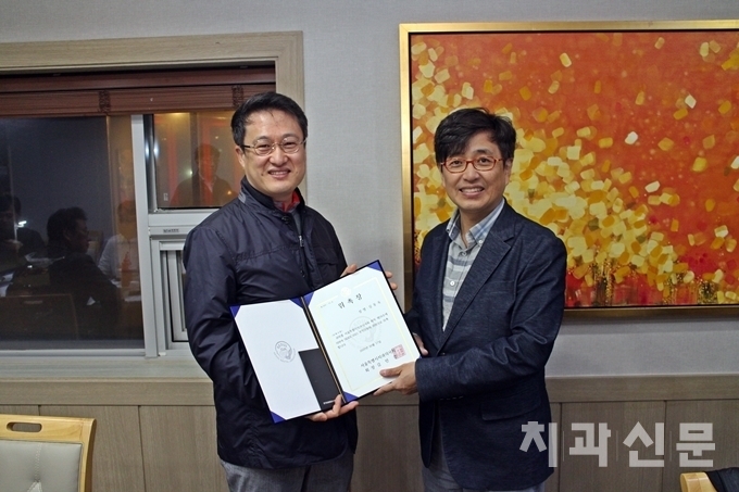 서울치과의사회 김민겸 회장(사진 우)이 심동욱 SIDEX 2021 조직위원(사진 좌)에게 위촉장을 전달하고 있다.
