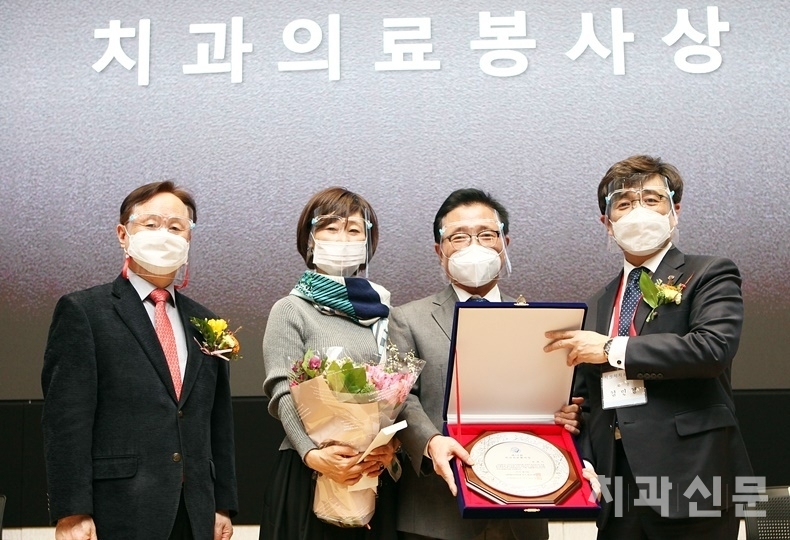 서울시치과의사회 김민겸 회장(사진 우)과 오스템임플란트 이광렬 덴올 본부장(사진 좌)이 제19회 치과의료봉사상 수상자인 최병기 회원에게 상패 등을 전달했다.