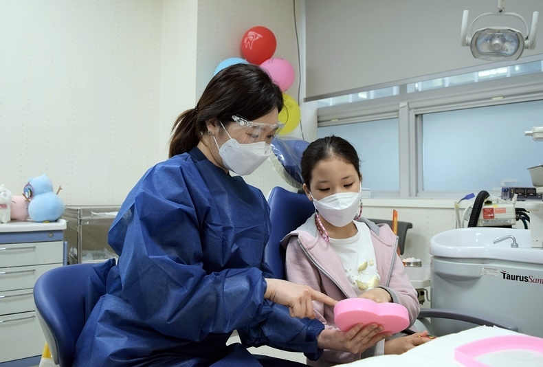 서울대치과병원 소아치과를 내원한 어린이 환자에게 진료가 끝난 후 선물을 증정하고 있다.