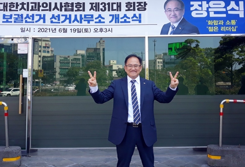 기호 2번 장은식 후보가 선거사무소 앞에서 후보자의 기호인 2번을 손으로 그려보이며 승리를 자신하고 있다.