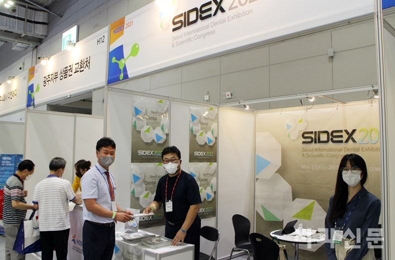 지난 3일 HODEX 2021 전시장에서 SIDEX 송종운 본부장이 부스를 방문한 업체 관계자에게 SIDEX 2022 전시참여 안내 브로슈어를 전달하고 있다.