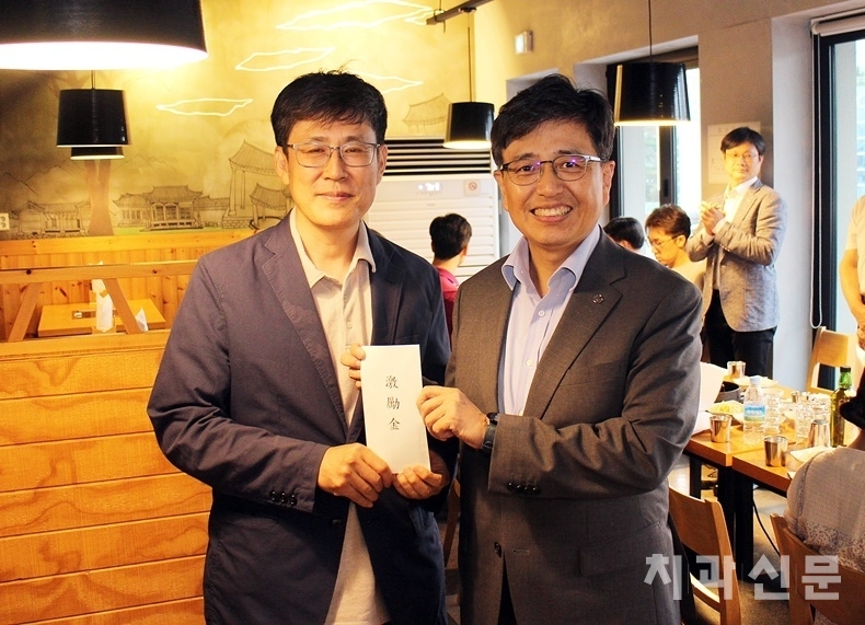 25개 구치과의사회 순방에 나서고 있는 서울시치과의사회 김민겸 회장(사진 오른쪽)이 영등포구치과의사회 김석중 회장(사진 왼쪽)에게 격려금을 전달하고 있다.