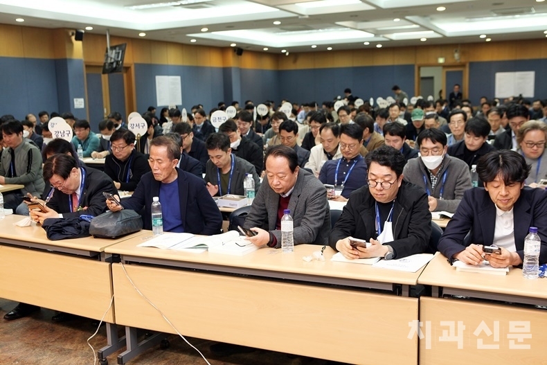 대의원총회에 참석한 대의원들이 휴대폰을 통해 표결을 하고 있다.