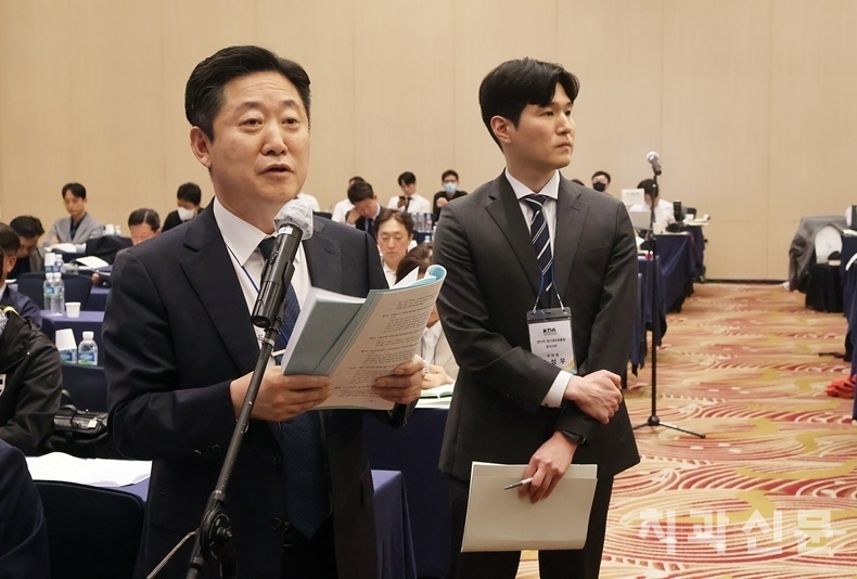 공직지부 권긍록 대의원이 '치과 전공의법 입법 재촉구의 건'에 대해 발언하고 있다. 뒤편에는 전공의인 주성우 대의원