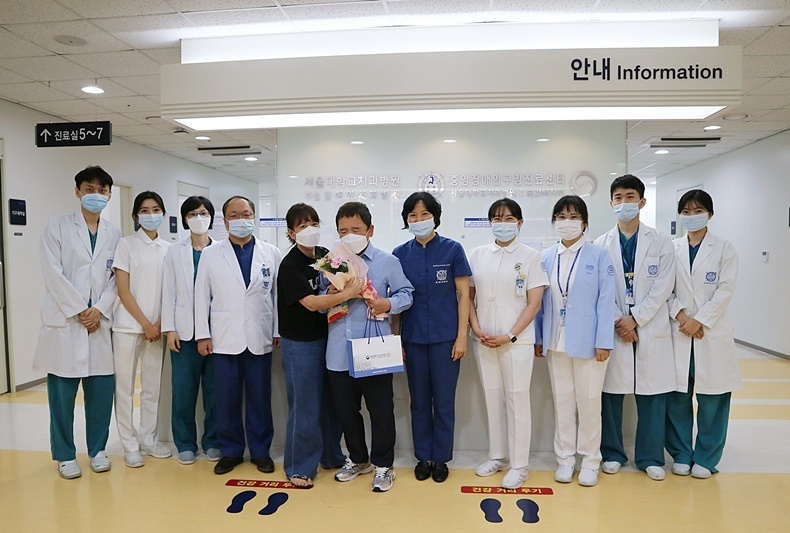 개원 4주년은 맞은 서울대치과병원 중앙장애인구강진료센터 의료진이 내원 환자에게 꽃다발과 기념품을 전달하고 있다.
