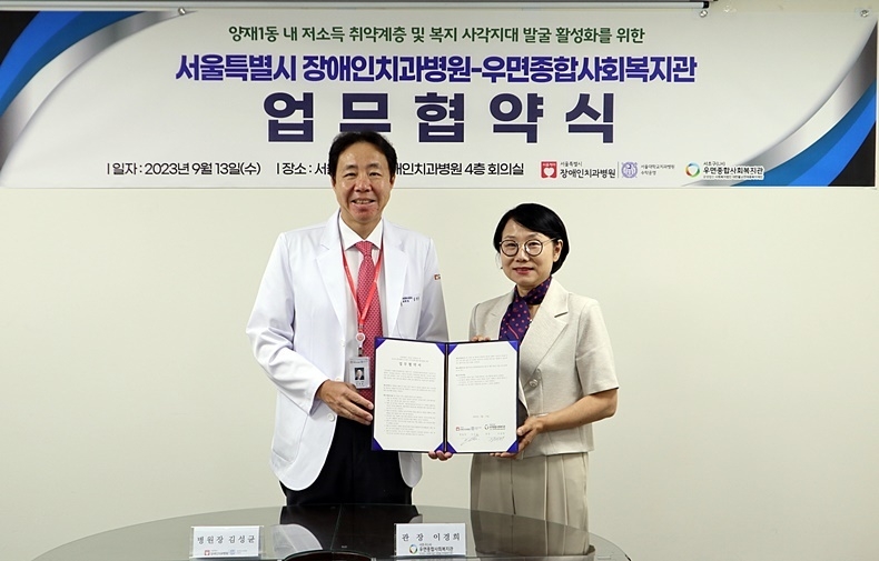 서울시장애인치과병원 김성균 원장(사진 좌)과 우면종합사회복지관 이경희 관장(사진 우)이 업무협약서를 들어보이고 있다. 사진제공_서울시장애인치과병원