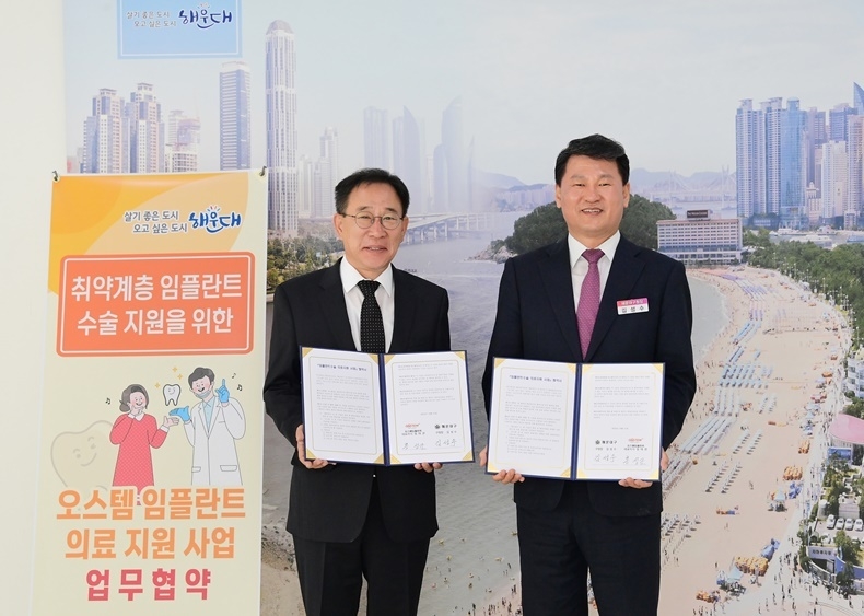 오스템 홍성조 생산총괄본부장(왼쪽)과 부산 해운대구 김성수 구청장이 지난달 31일 ‘취약계층 임플란트 수술 지원을 위한 업무협약’을 맺었다(사진제공_오스템임플란트).