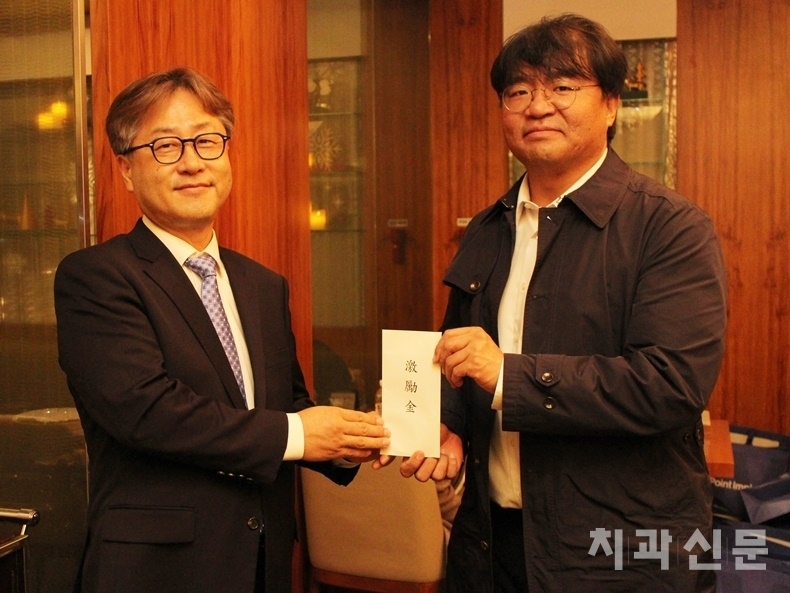 서울지부 함동선 부회장(왼쪽)이 조일환 회장에게 격려금을 전달하고 있다.
