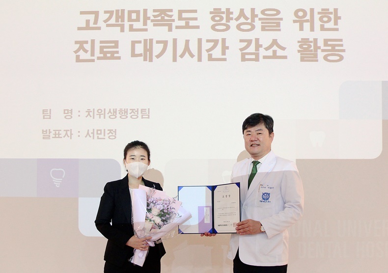 서울대치과병원 이용무 원장(사진 오른쪽)이 치위생행정팀을 대표해 서민정 치과위생사(사진 왼쪽)에게 대상을 전달하고 있다. (사진제공_서울대치과병원)